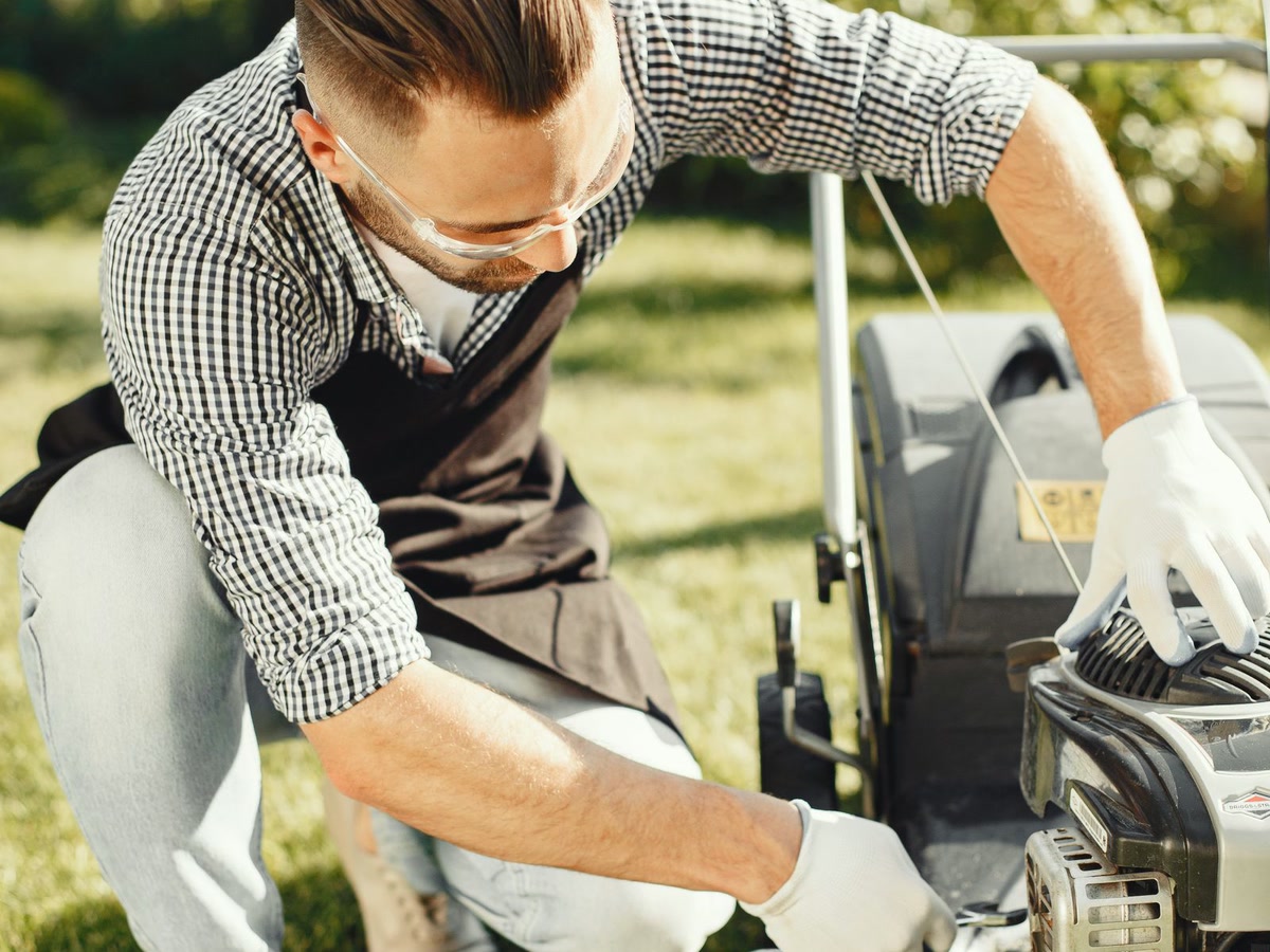 Servis a oprava sekačky: ruce mechanika u motoru